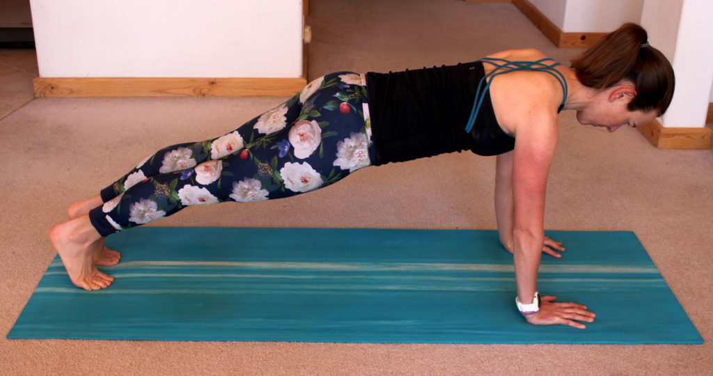 a woman performing a plank on hands exercise for a proper push up