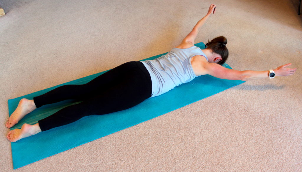 A woman demonstrating an exercise in preparation for doing a push up.