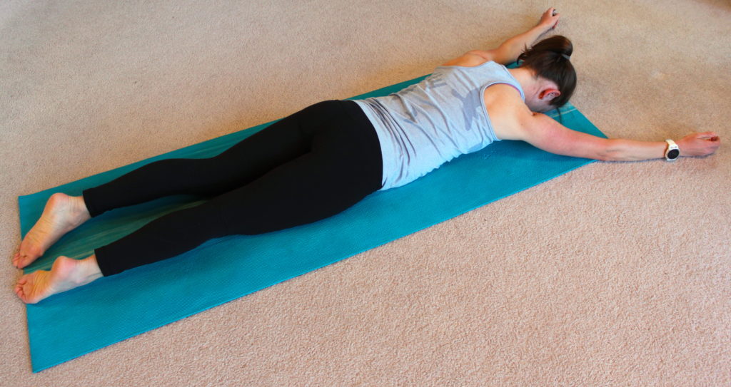 A woman demonstrating an exercise in preparation for doing a push up.